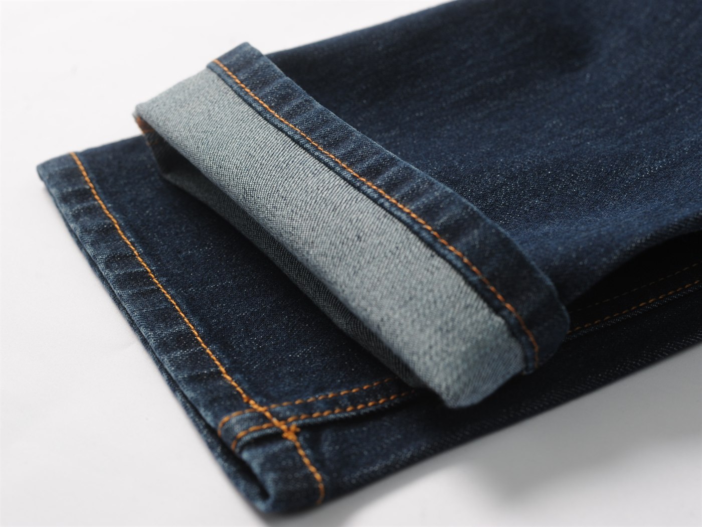 Detail jahitan hem pada ujung pipa kaki jeans dengan lipatan terbuka